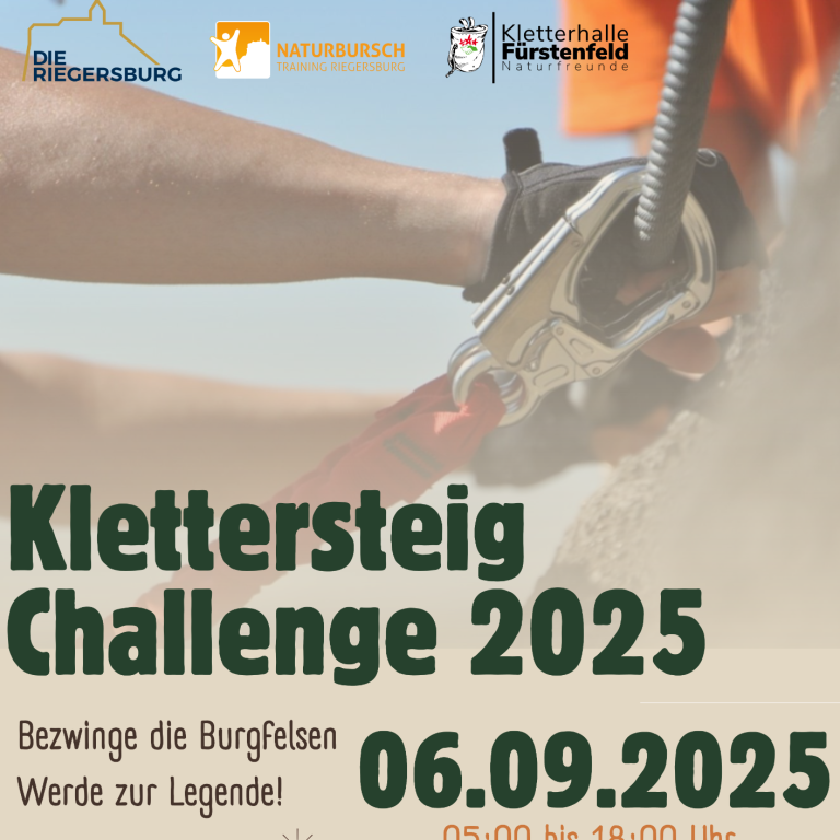 Kletterer mit grünem Helm, der an einem Klettersteig ein Jubel mit gestrecktem Arm zeigt.