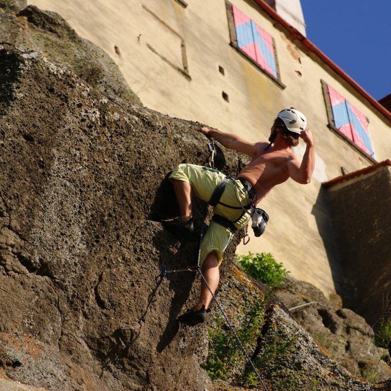 Gruppe von Kletterern und Unterstützern vor einer Kletterwand, inklusive Rollstuhlnutzern.